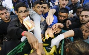 Imigrantes pegam comida oferecida por voluntários enquanto aguardam registro em Berlim