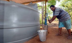 O agricultor Floriano da Silva bombeia água da cisterna no quintal de casa